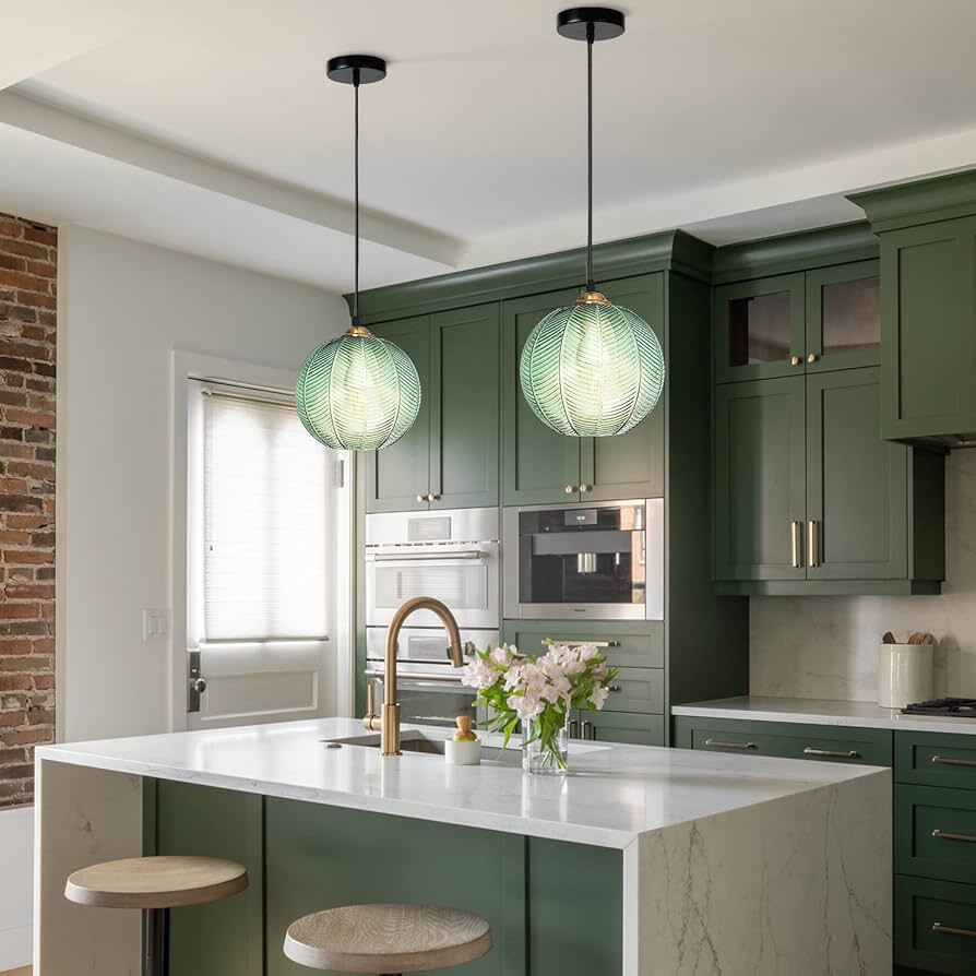 Isla de cocina con lámparas flotantes modernas sobre la encimera, creando un ambiente elegante y funcional